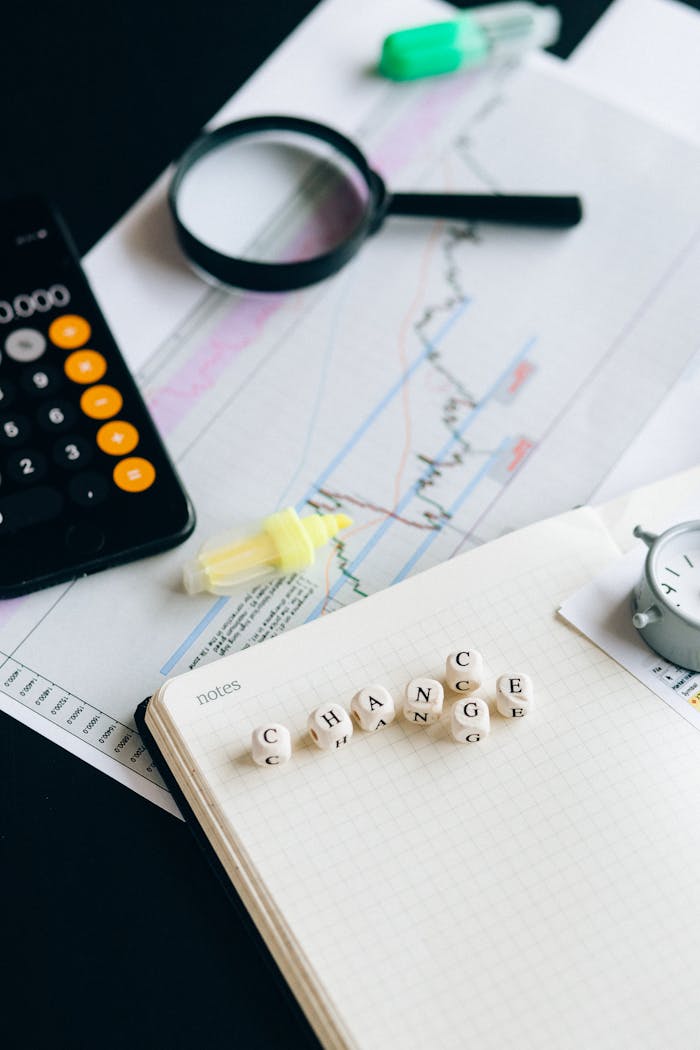 Close-up of financial tools and letter blocks spelling CHANGE.